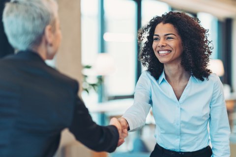 Smiling businesswoman greeting a colleague on a meeting